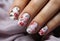 Luxury manicure with drawing flowers. Closeup Woman hand with beautiful nail design. Female hand with stylish, creative and
