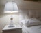 Luxury modern design of a bright bedroom with a bedside table and a night light and a pillow on the bed, preparing for