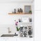 Luxury modern white kitchen with professional barista espresso machine on quartz countertop. Square crop of interior