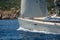 Luxury new cruising sailboat bow with teak deck under hoisted sails.