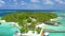 Luxury overwater villas with coconut palm trees, blue lagoon, white sandy beach at Bora Bora island, Tahiti, French