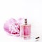 Luxury perfume bottle and pink peony flower isolated on white background. Female cosmetic and makeup accessory still life