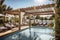 luxury pergola with sun loungers and parasols, surrounded by sparkling swimming pool