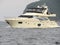 Luxury pleasure motor boat sailing along the steep green coast