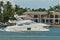 Luxury powerboat cruising tropical canal and condominiums