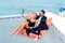 Luxury relaxing couple traveler in nice dress and suite sit on bean bag and drink a glass of wine in part of cruise yacht with