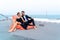 Luxury relaxing couple traveler in nice dress and suite sit on bean bag in part of cruise yacht with background of sea and white