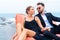 Luxury relaxing couple traveler in nice dress and suite sit on bean bag in part of cruise yacht with background of sea and white