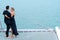 Luxury relaxing couple traveler in nice dress and suite stand and hug in love at part of cruise yacht with background of sea and