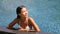 Luxury resort woman relaxing in infinity swim pool