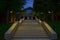 Luxury restaurant estate space entrance stairs in park illuminated by design lanterns, evening twilight lighting environment