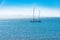 Luxury sailing boat in the atlantic ocean with unrecognizable crew members on the deck. Fuerteventura Island in the