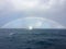 Luxury sailing yacht under a rainbow on the open sea