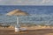 Luxury sand beach with beach chairs and straw umbrellas in tropical resort in Red Sea coast in Egypt, Africa