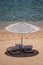 Luxury sand beach with beach chairs and white straw umbrella in tropical resort in Red Sea coast in Egypt, Africa