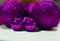 Luxury, shiny, large and small purple Christmas balls close-up on a white table at home. Bright Christmas decorations. Selective f
