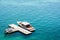 A luxury speedboat moored to an isolated wooden dock in green waters