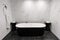 Luxury stand alone black bathtub in a dully tiled bathroom