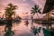 Luxury swimming pool in tropical resort, relaxing holidays in Seychelles islands. La Digue, Young man during sunset by