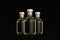 Luxury three glass bottles for cosmetic, perfume, drink with black label, cork, yellow liquid on dark black background, mock up.