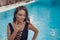 Luxury travel bikini girl with sexy body in black swimwear posing by swimming pool at luxurious villa. High fashion colors,