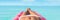 Luxury travel caribbean tropical beach vacation banner panoramic bikini woman sunbathing on air mattress. Legs suntan