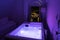 Luxury travel Santorini vacation hotel jacuzzi in colored lights with night view of the city.