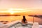 Luxury travel Santorini vacation woman swimming in hotel jacuzzi pool watching sunset. Europe resort destination holiday for
