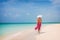 Luxury travel vacation elegant lady walking on beach in pink fashion skirt wrap relaxing on Caribbean holidays in winter