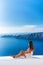 Luxury travel vacation Europe tourist woman relaxing at fancy hotel resort balcony in greek Santorini island, Greece