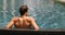 Luxury travel wellness spa retreat - man relaxing in swimming pool