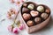 Luxury valentine chocolates in heart shaped gift box and tender flowers