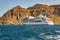 Luxury white cruise ship near high rocks on the greek island of Santorini