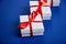 Luxury white gift boxes with red ribbon on blue trend color background. Valentine Day, Christmas, birthday party presents. Mother