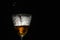 Luxury wine pouring in beautiful misted vintage glass on black background