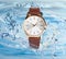 Luxury women`s watch in water splashes demonstrating its waterproof