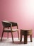 Luxury wooden chair with polished wooden table with three legs in a space with pink wall and cream floor with ambient light