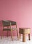 Luxury wooden chair with polished wooden table with three legs in a space with pink wall and cream floor with ambient light