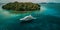 Luxury Yacht anchored in tropical paradise. Aerial view of yacht surrounded by crystal-clear turquoise waters anchored in a