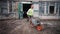 Lviv, Ukaraine - 30.09.2023: A construction worker in a helmet takes out concrete waste on a wheelbarrow and dumps it on