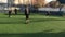 LVIV, UKRAINE - APRIL 14, 2019: Guys in the evening on a sunny day playing football on a mini artificial grass field