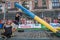 LVIV, UKRAINE - AUGUST 2017: A strong bodybuilder athlete lifts a huge steel heavy pipe to the strongman game in front of enthusia