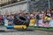 LVIV, UKRAINE - AUGUST 2017: A super strong athlete raises a huge Good year wheel at competitions in front of enthusiastic spectat