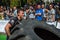 LVIV, UKRAINE - AUGUST 2017: A super strong athlete raises a huge Good year wheel at competitions in front of enthusiastic spectat