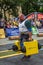 LVIV, UKRAINE - JULY 2016: Mighty strong athlete bodybuilder strongman carries heavy iron suitcases on the street in front of