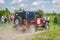 LVIV, UKRAINE - MAY 2016: Huge tuned car Jeep SUV driving on a dirt road rally, raising a cloud of dust behind, among the