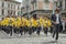 LVIV, UKRAINE - MAY 2018: A brass band with trumpets and saxophones in carnival costumes with yellow jackets is walking along the