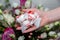 LVIV, UKRAINE - May 25, 2020: Woman holding Raffaello sweets on the hand. Beaituful flowers on background. Perfect present