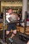 LVIV, UKRAINE - NOVEMBER 2016: Strong athlete strongman carries heavy iron suitcases