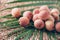 Lychee fruits with palm leaves on rattan background. Copy space. Exotic litchi, lichee fruits. Tropical food concept